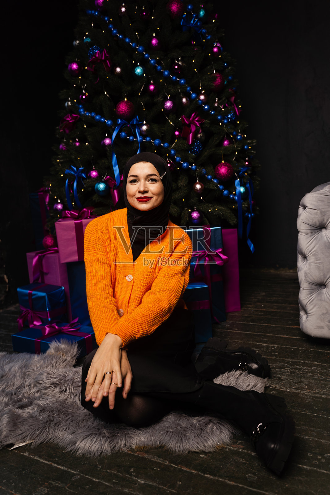 戴着黑色头巾的穆斯林女孩在新年假期梦想得到礼物。伊斯兰教徒的圣诞节庆祝活动。照片摄影图片