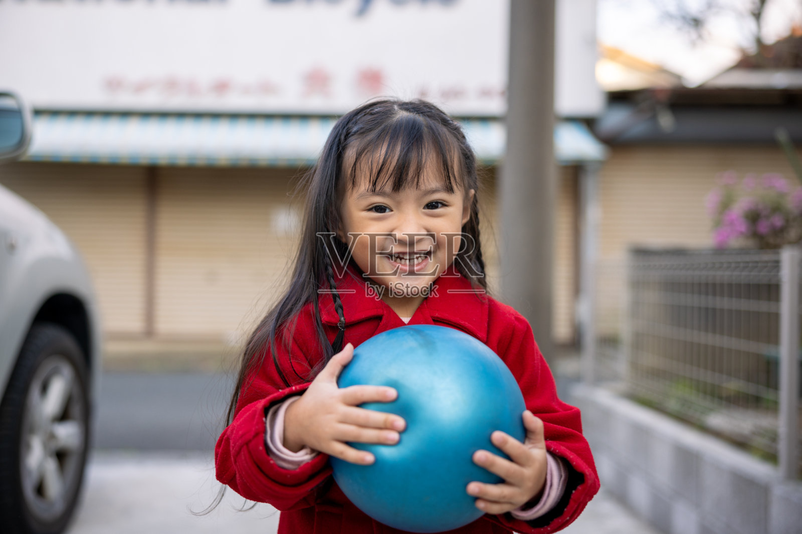 小女孩在开车前在停车场玩耍的肖像照片摄影图片