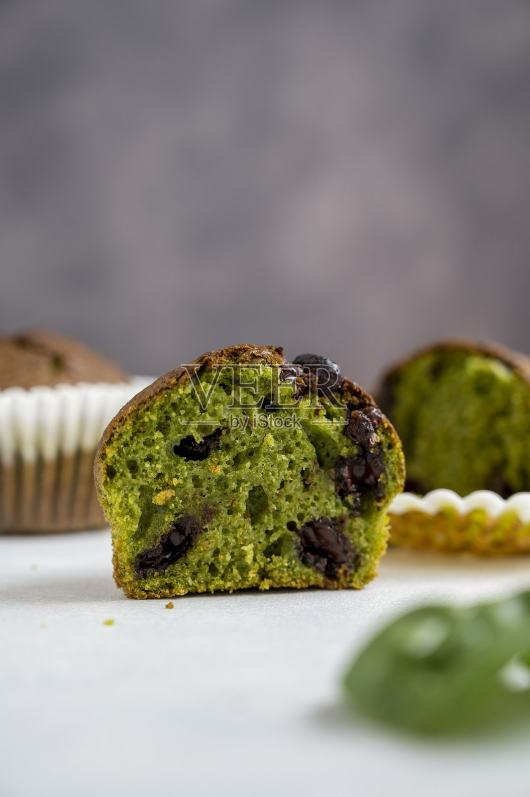 菠菜松饼。半块绿色松饼配上新鲜菠菜叶。家庭烘焙。照片摄影图片