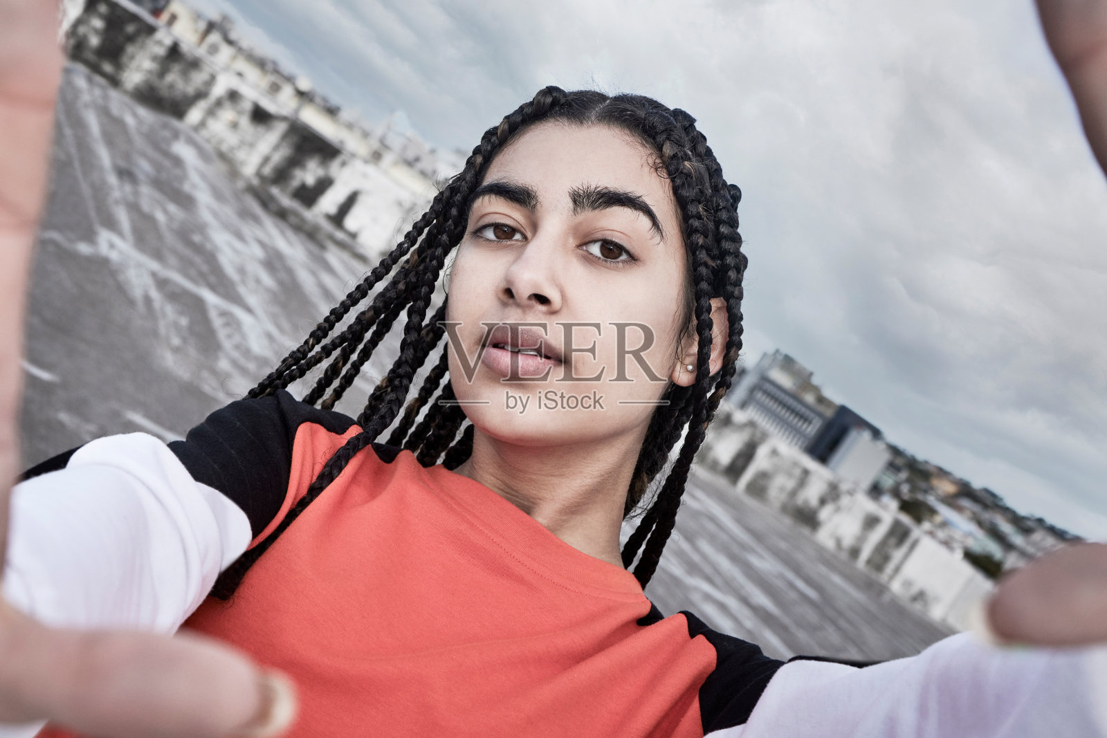 裁剪的肖像，一个有吸引力的年轻女舞者自拍，而站在屋顶上反对暴风雨的背景照片摄影图片