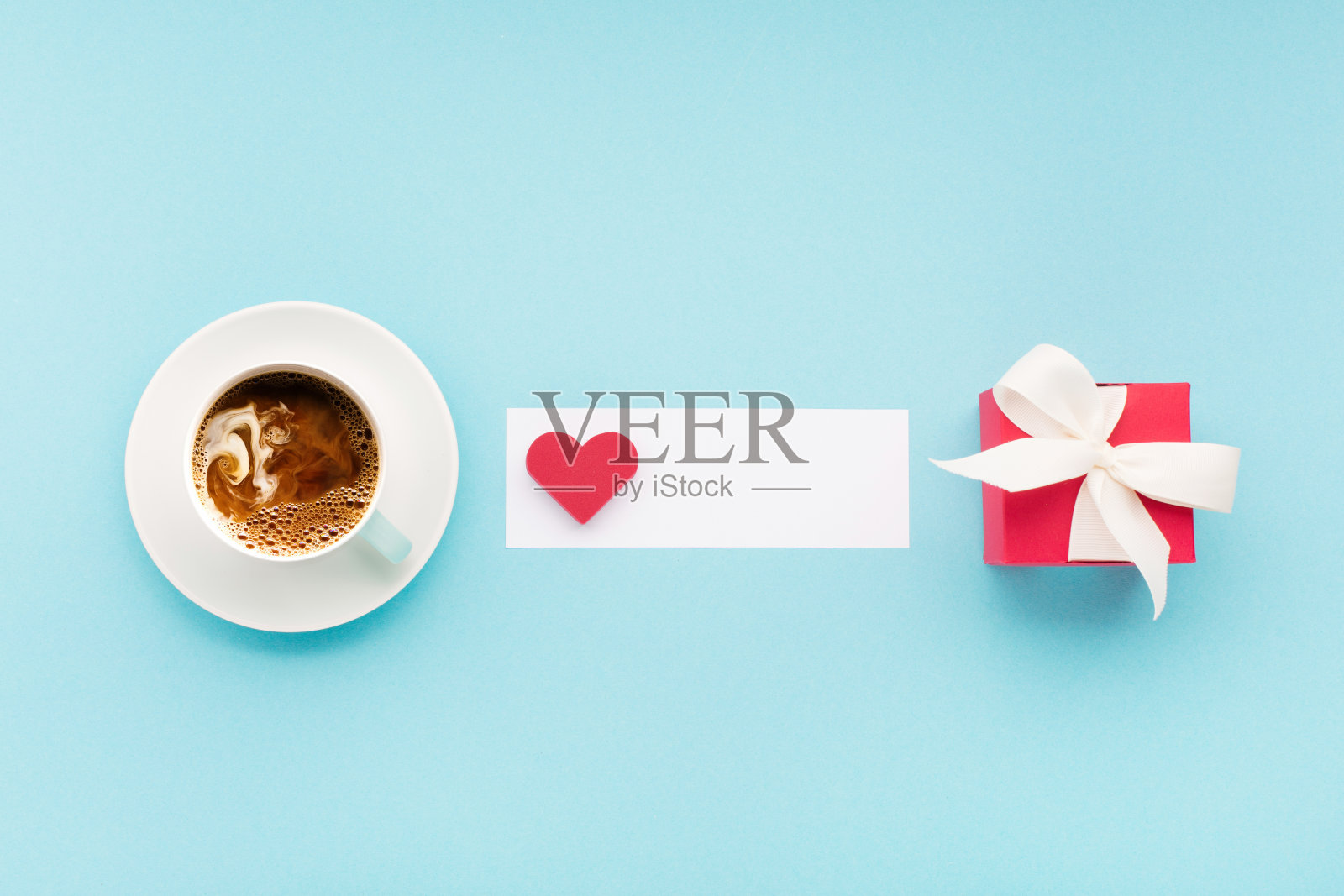 情人节节日贺卡。红色礼品盒，蓝色背景上的心形和一杯咖啡。情人节的概念。照片摄影图片