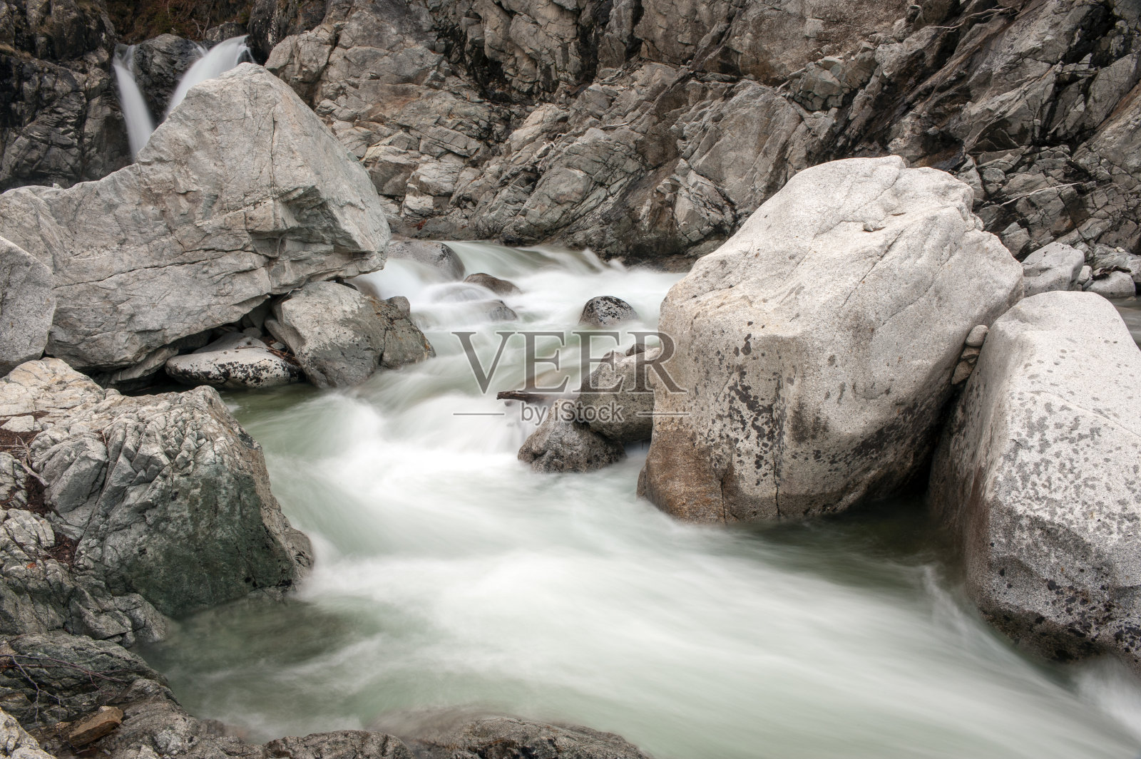 快速流过岩石的水。照片摄影图片