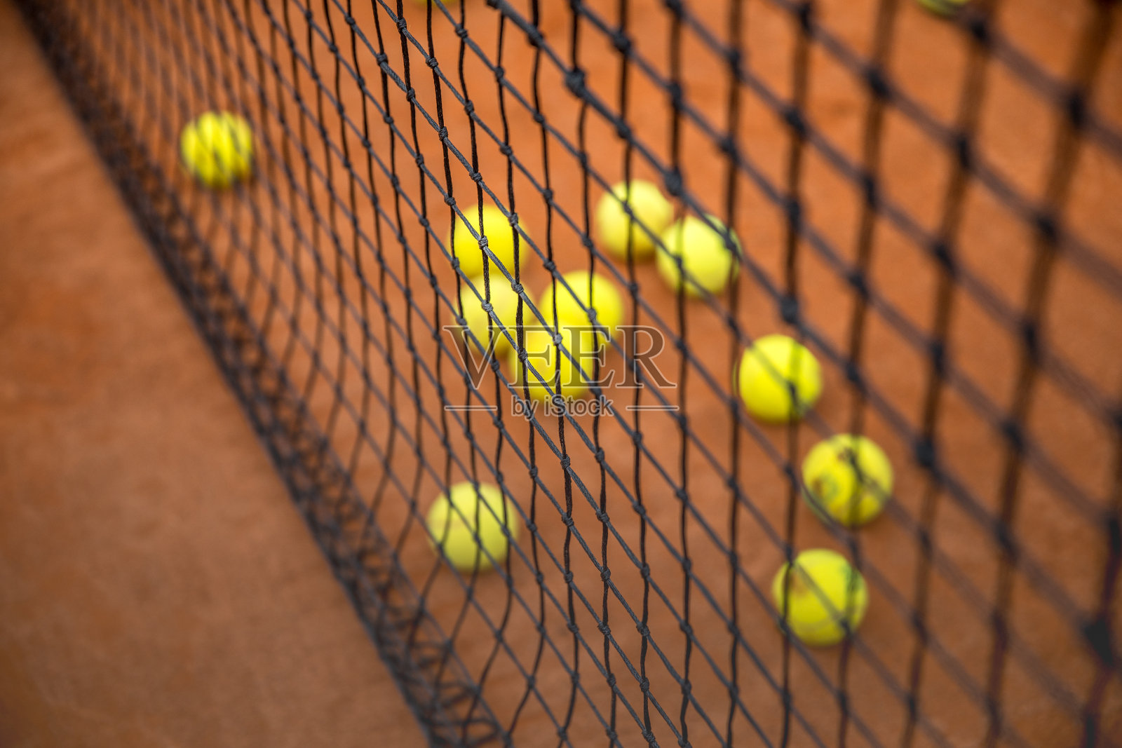 散落在红土网球场上的网球照片摄影图片