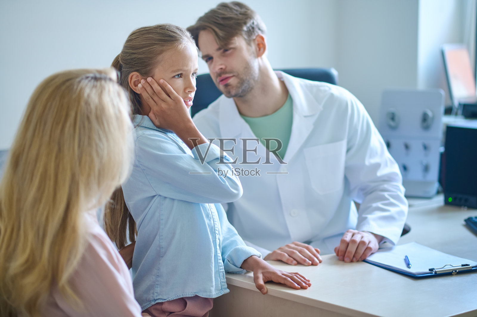 专注的女孩倾听，触摸耳朵，专心听力学家照片摄影图片