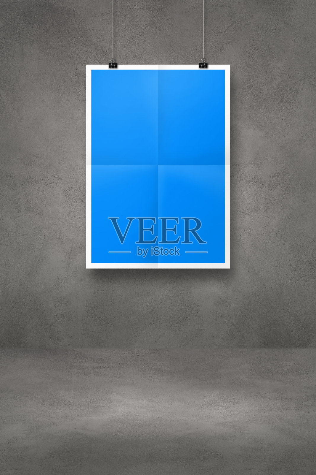 蓝色的折叠海报挂在深色的混凝土墙上，墙上有夹子照片摄影图片