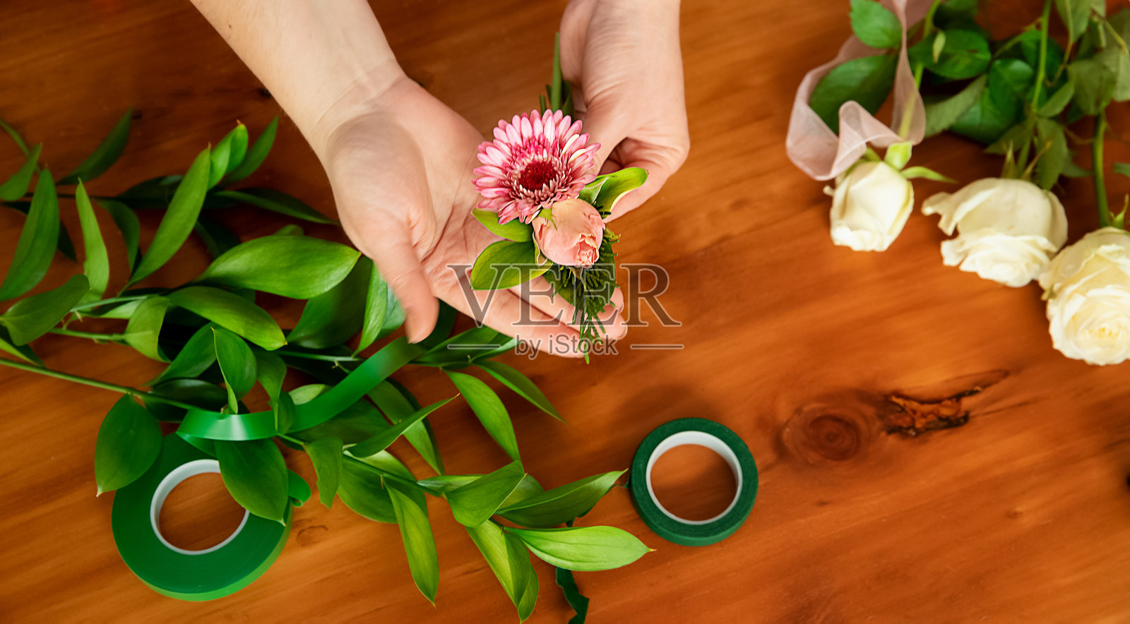 花商手捧鲜花，制作花束或插花，花商大师班或作坊照片摄影图片