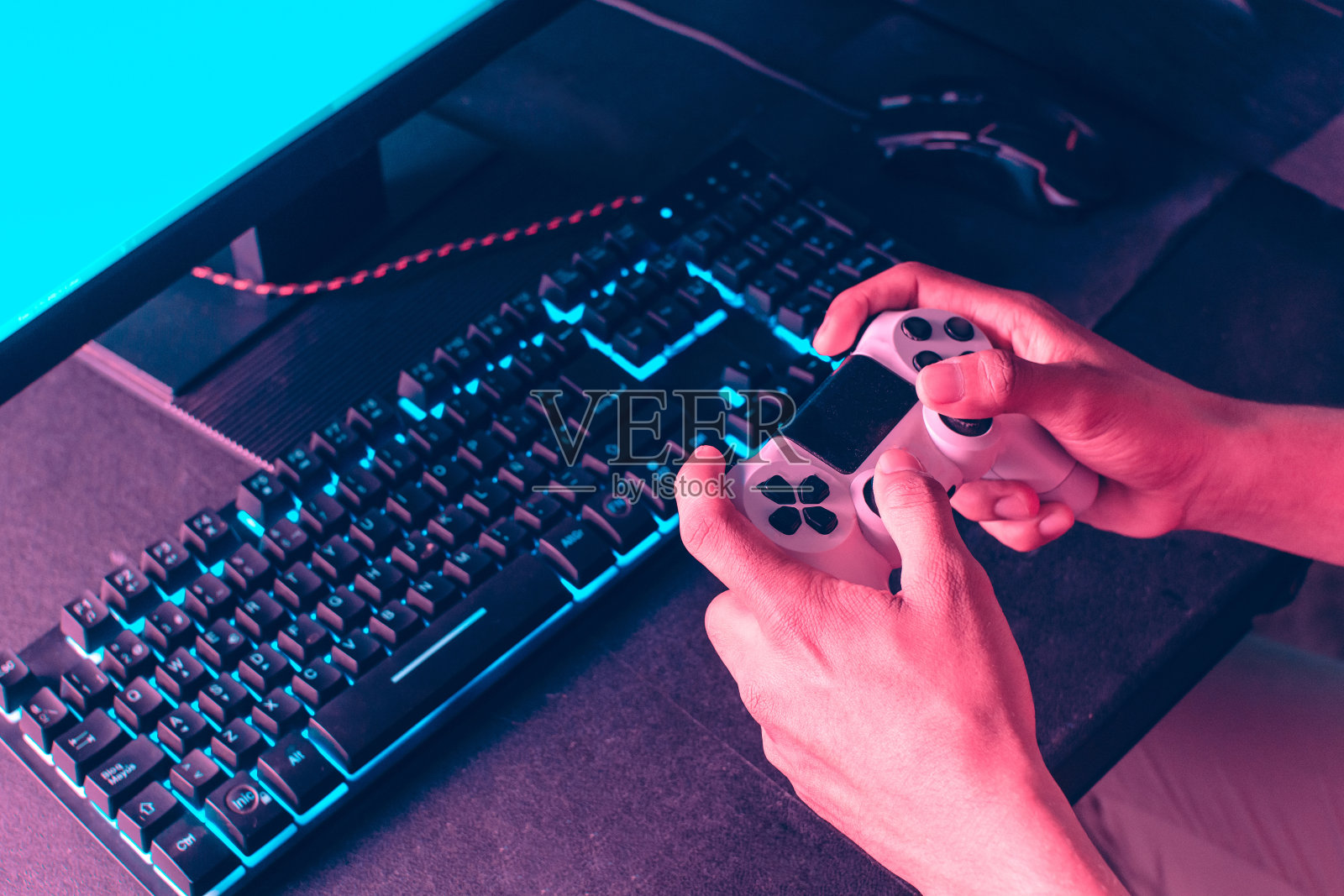 手握操纵杆在显示器前玩视频游戏。照片摄影图片