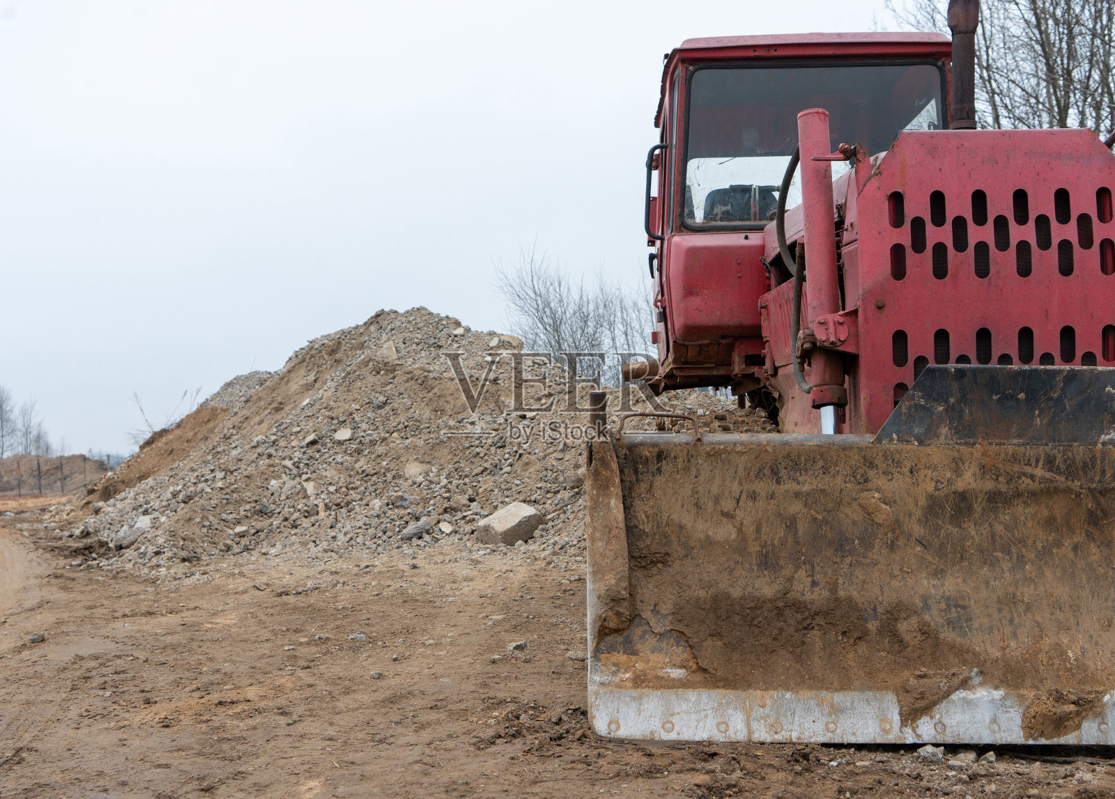 这是一张苏联推土机的照片，背景是堆积如山的沙子和石头照片摄影图片