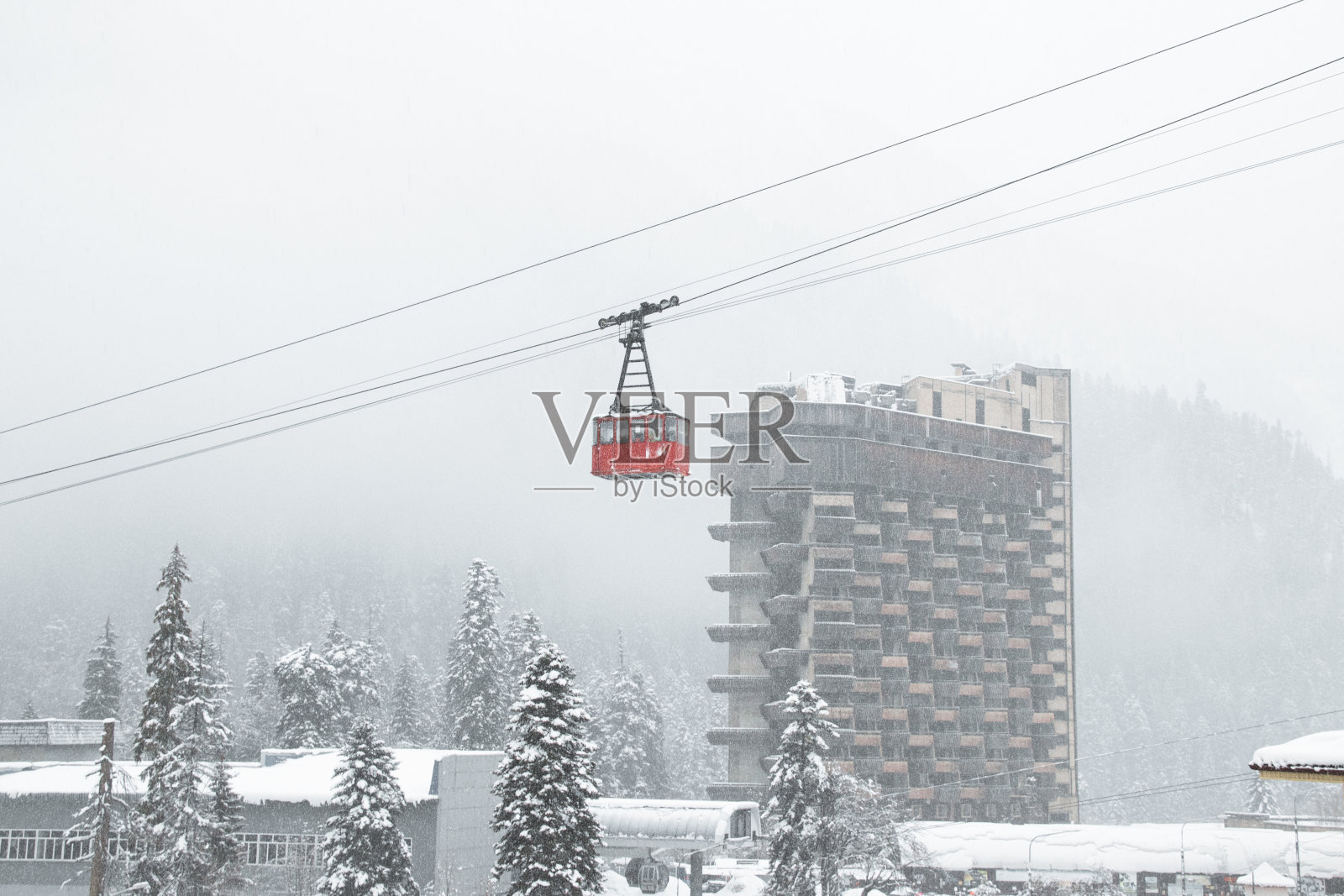 红色的小屋在高加索山脉的大雪中照片摄影图片