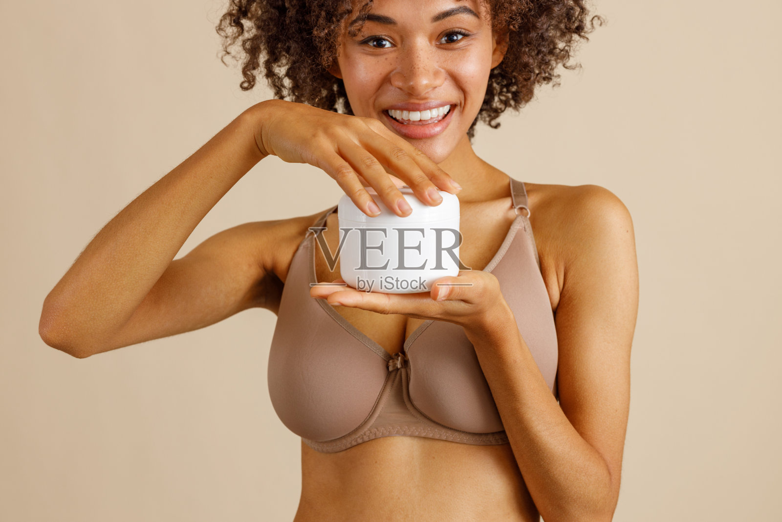 年轻女子拿着瓶子与美容产品在工作室照片摄影图片