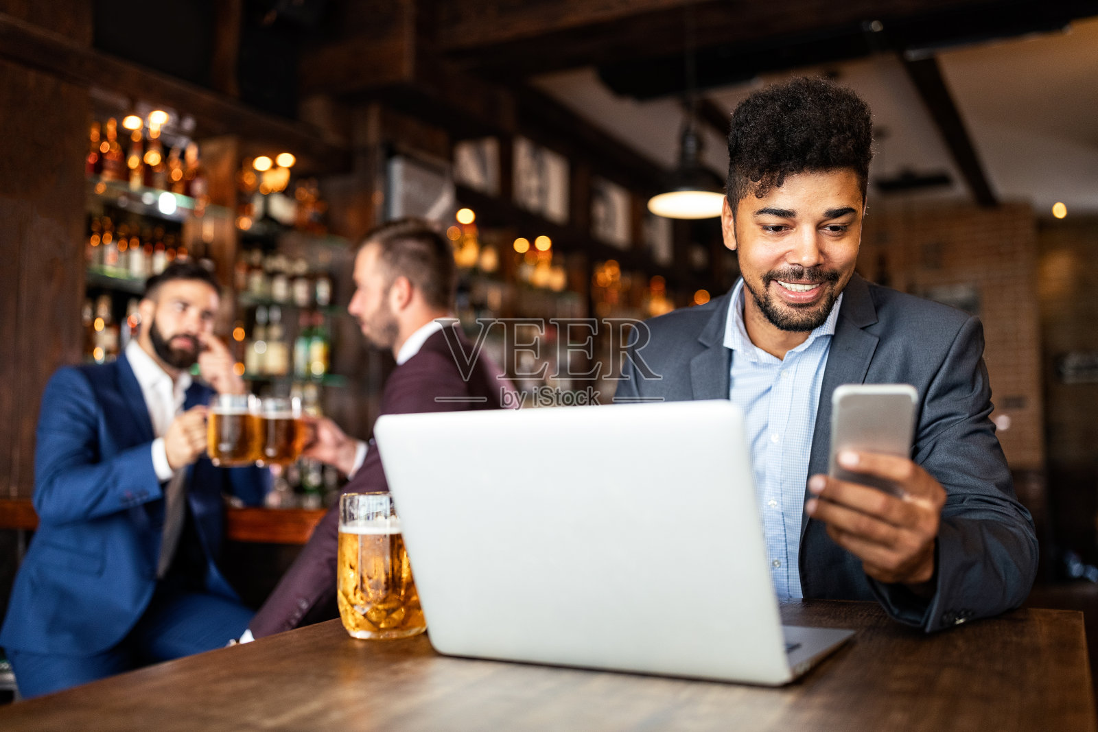 一个成功的商人的肖像坐在咖啡馆工作的笔记本电脑。照片摄影图片