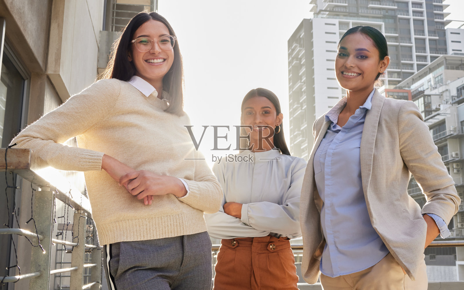 三个有吸引力的年轻女商人站在办公室阳台上的裁剪肖像照片摄影图片