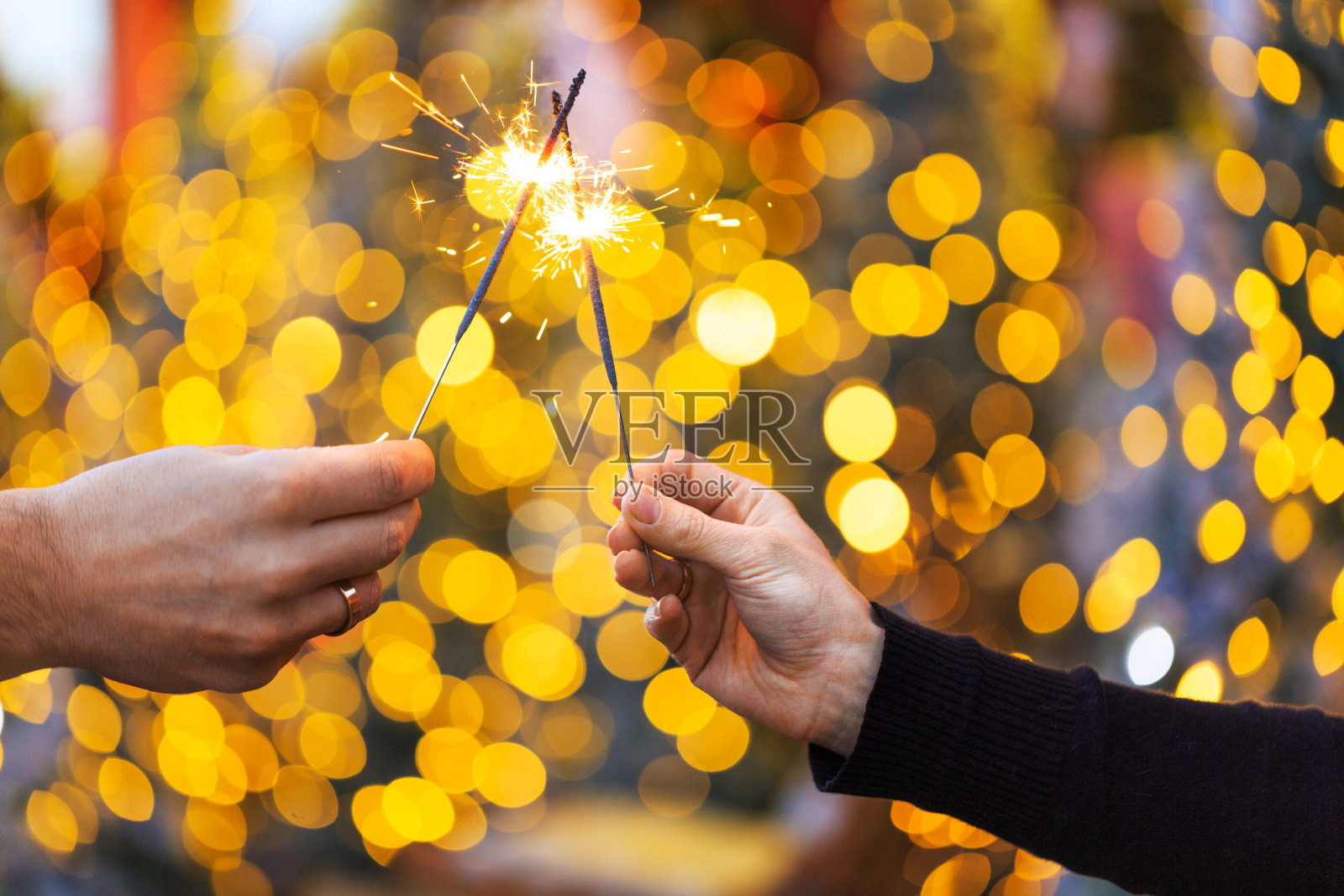 两只手拿着烟火在圣诞节或新年前夕的背景照片摄影图片