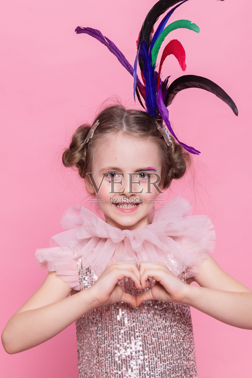 一个穿着粉红色衣服，戴着生日帽的小女孩坐在地板上照片摄影图片