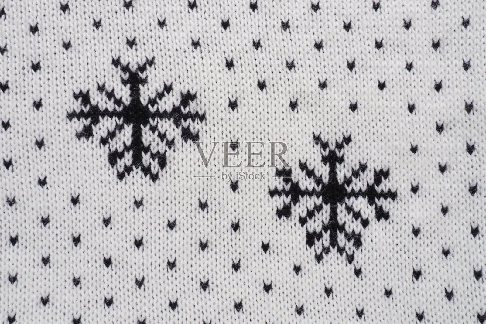 提花针织图案。圣诞节或新年的几何装饰。在白色的背景上编织黑色的雪花和圆点。冬季时尚现代传统民间服饰点缀照片摄影图片