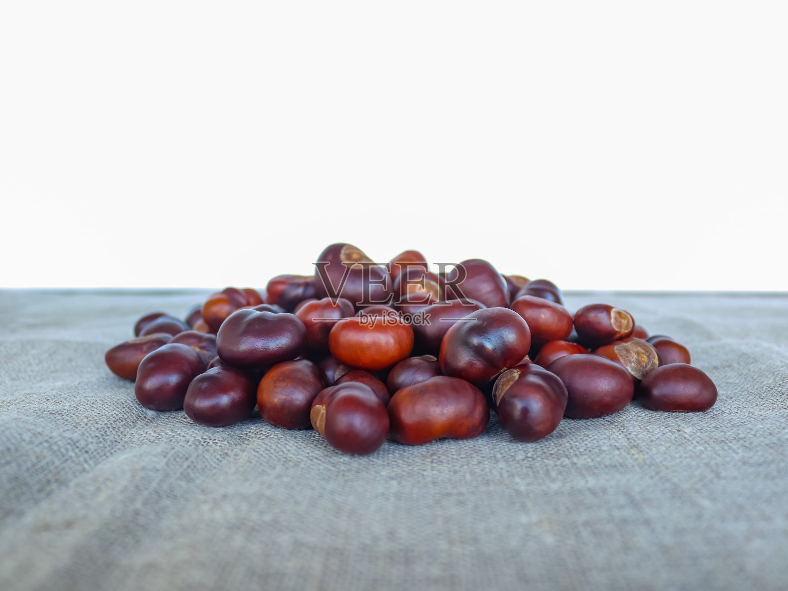 纺织背景上的一堆栗子照片摄影图片