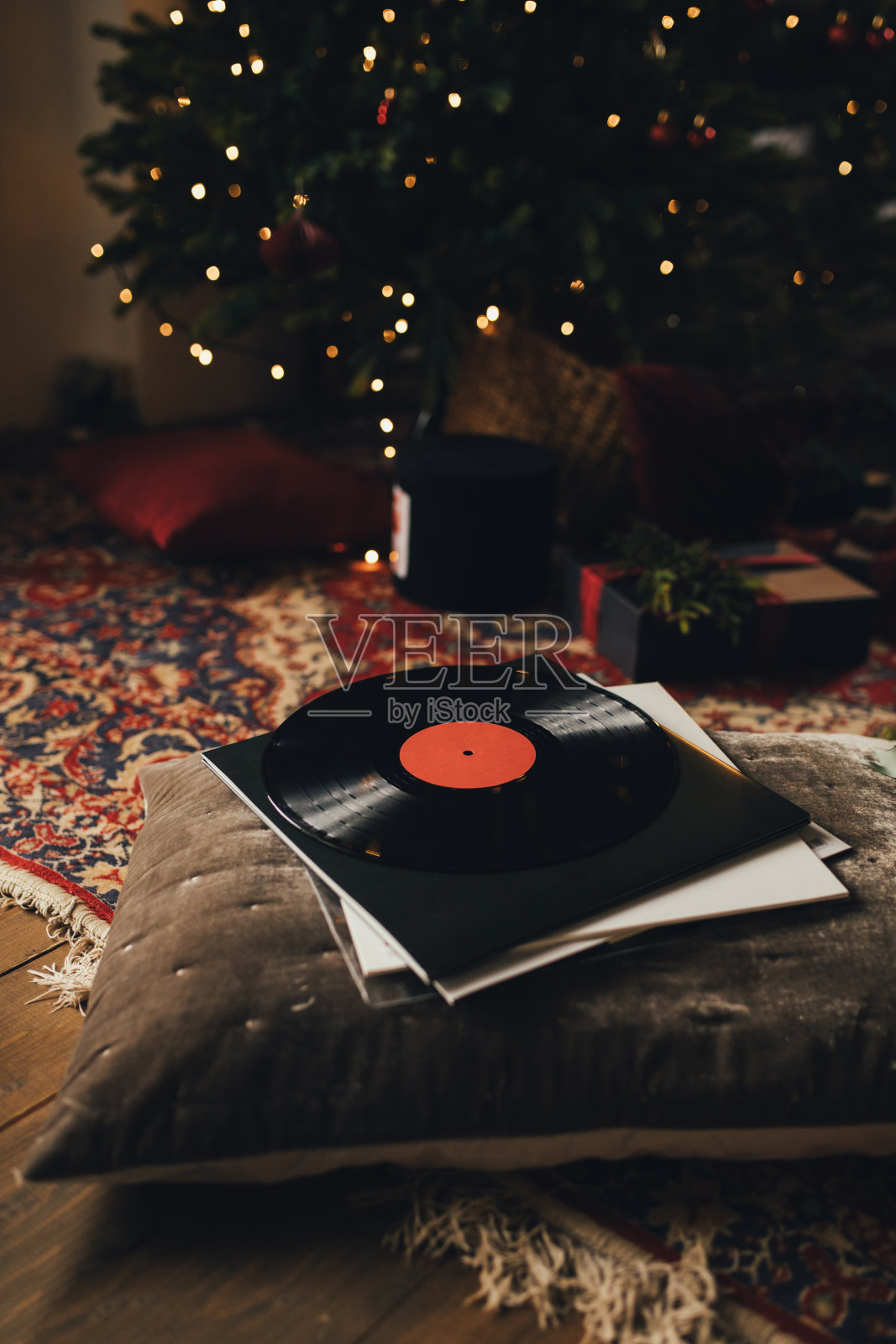 枕头上有乙烯基唱片，背景是圣诞树。节日装饰。照片摄影图片