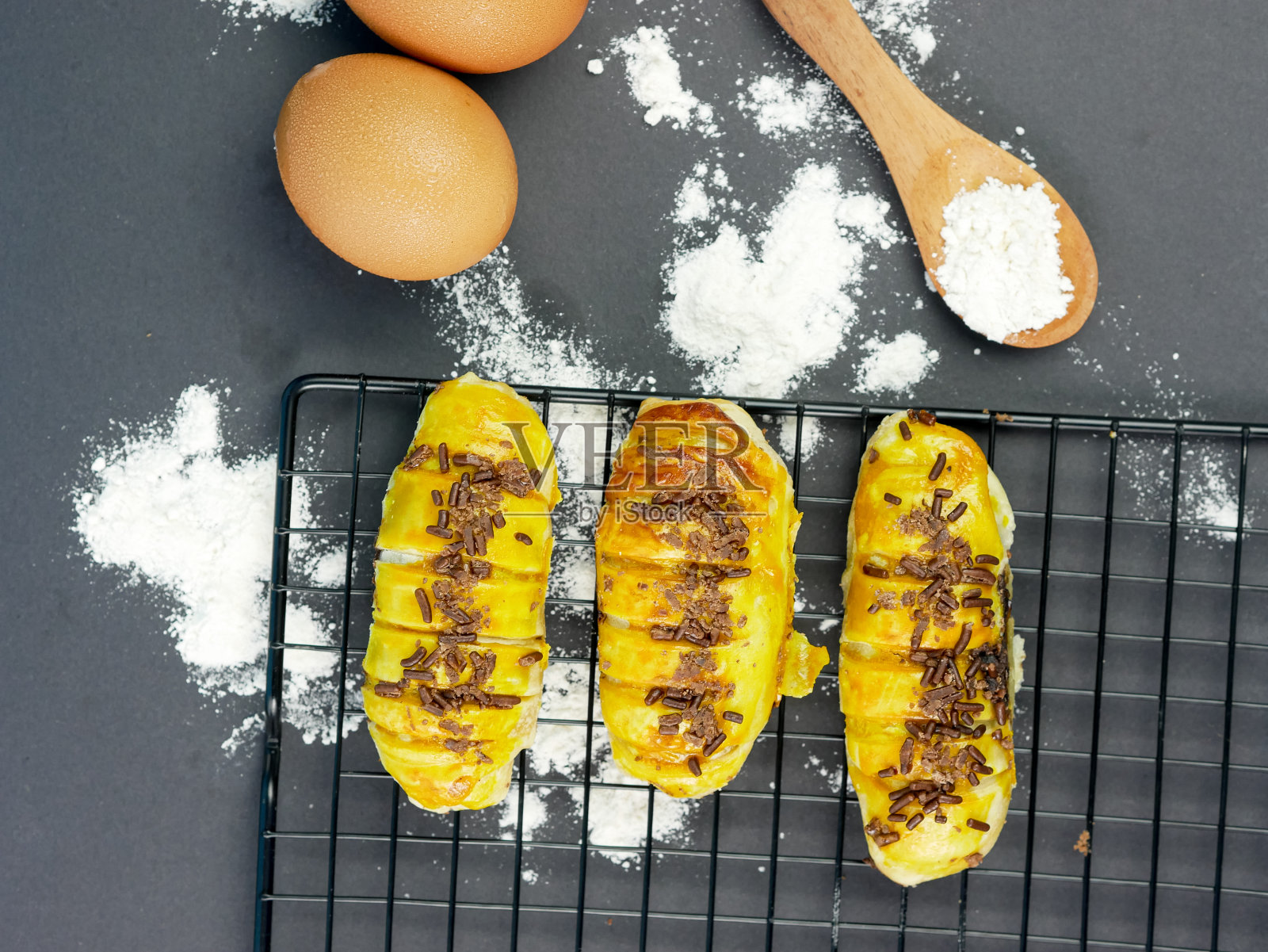 博伦面包是一种典型的印尼面包，放在黑色背景的冷却架上。照片摄影图片