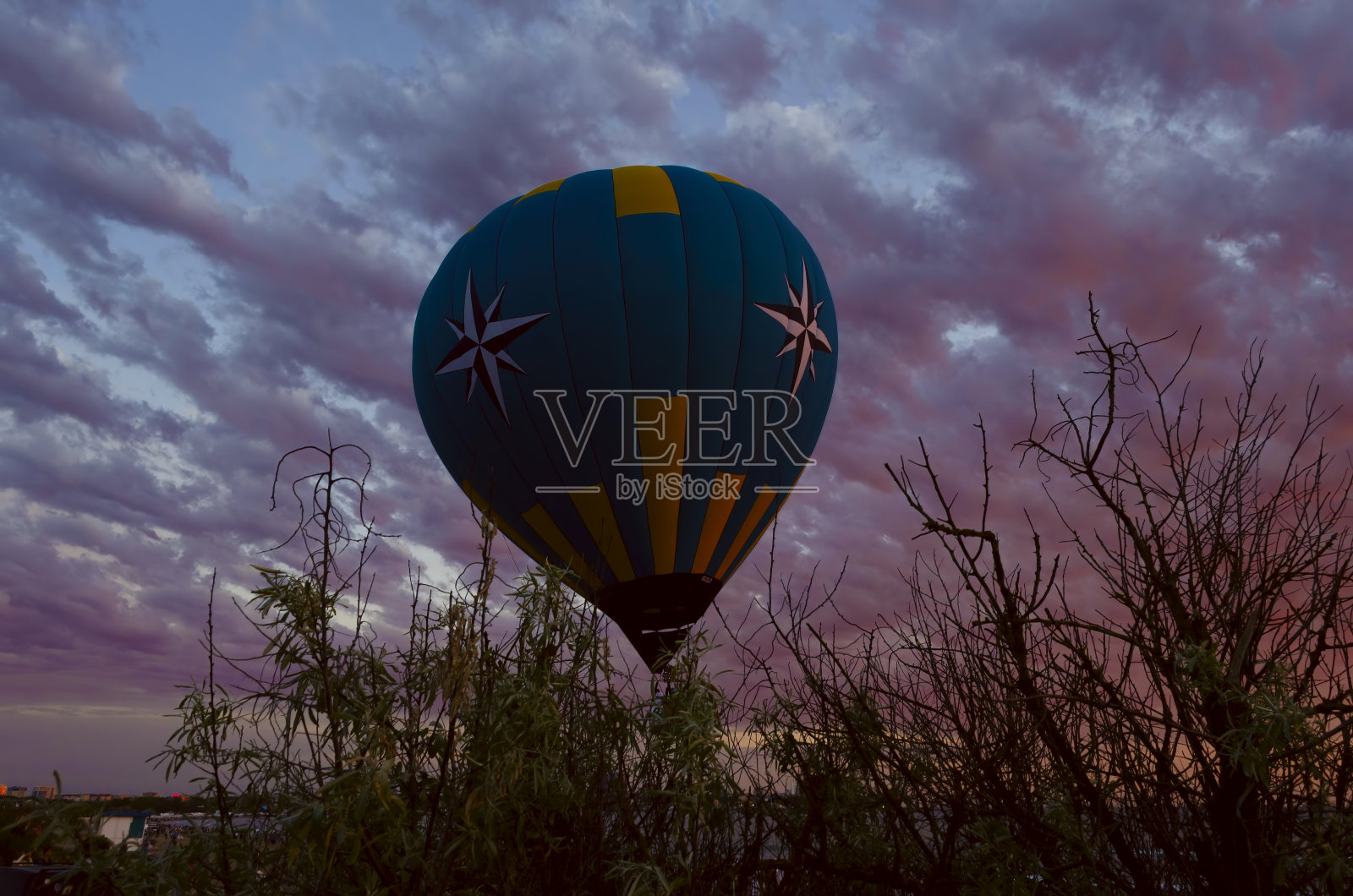 日落时，热气球在海上飞行照片摄影图片