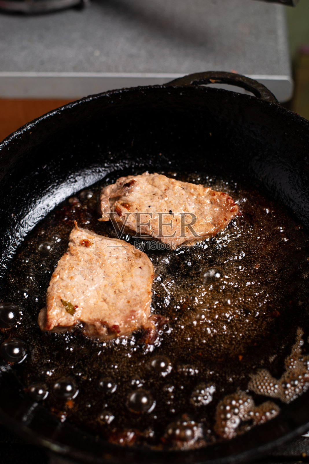 煎锅里的烤猪肉片。照片摄影图片