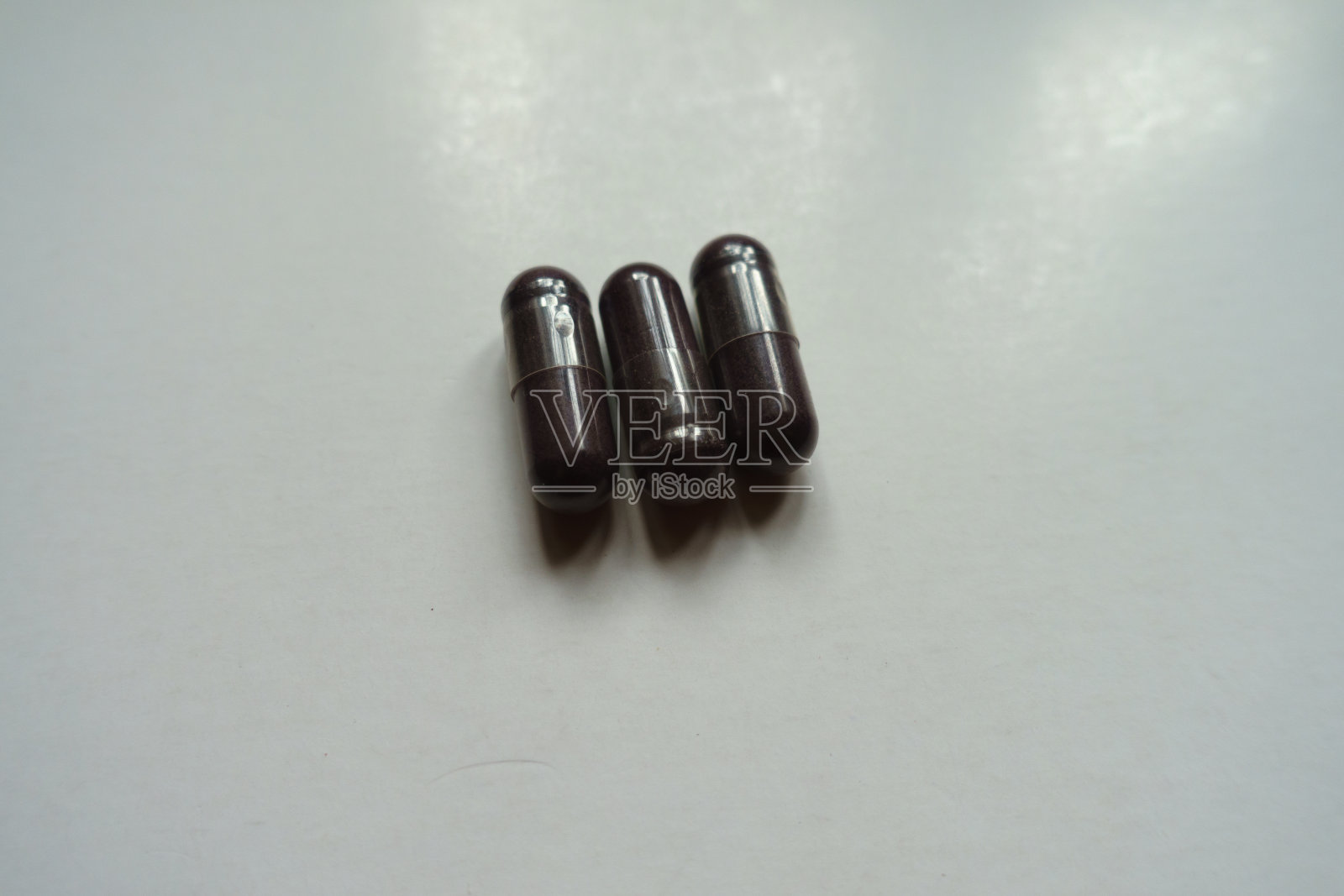 近距离观察三个深紫色的越橘萃取胶囊膳食补充照片摄影图片
