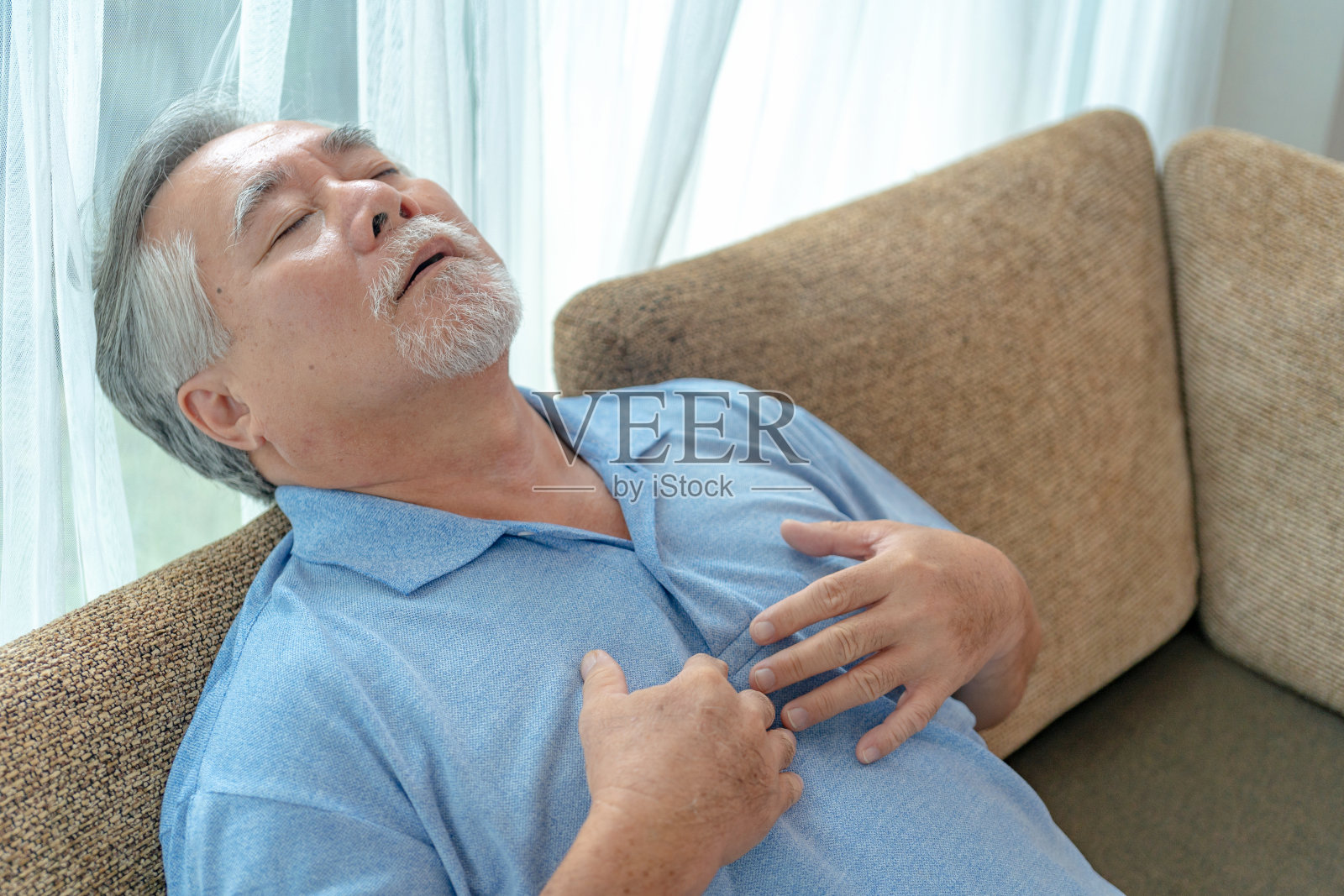 成熟的亚洲男人胸痛。照片摄影图片