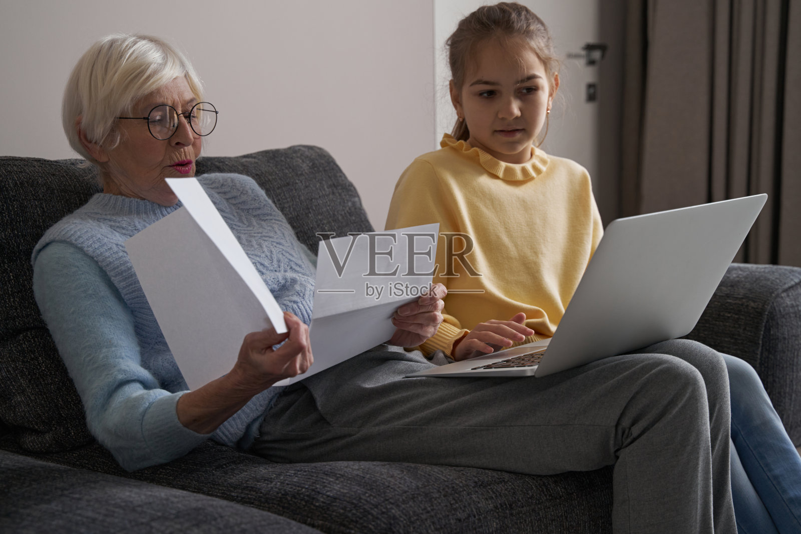 忙碌的祖母和小女孩，看起来任务繁重照片摄影图片