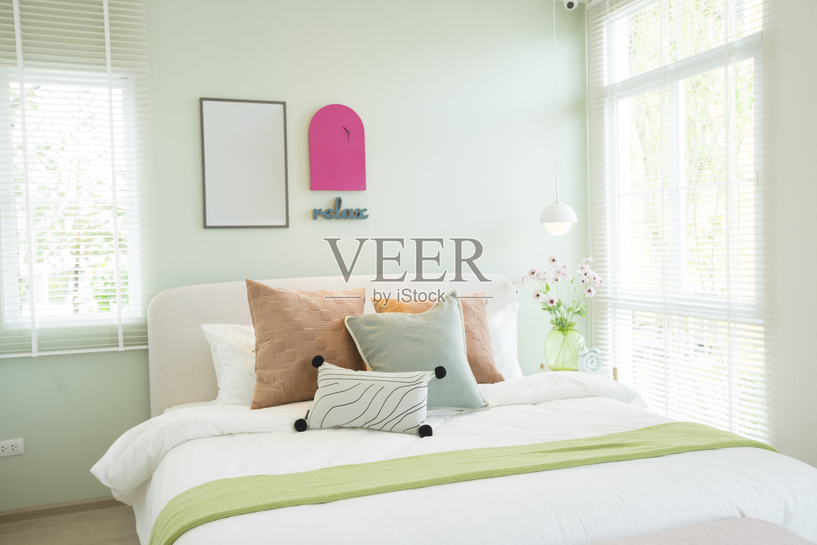 时尚的卧室与现代的绿色和粉红色的枕头和家具。照片摄影图片