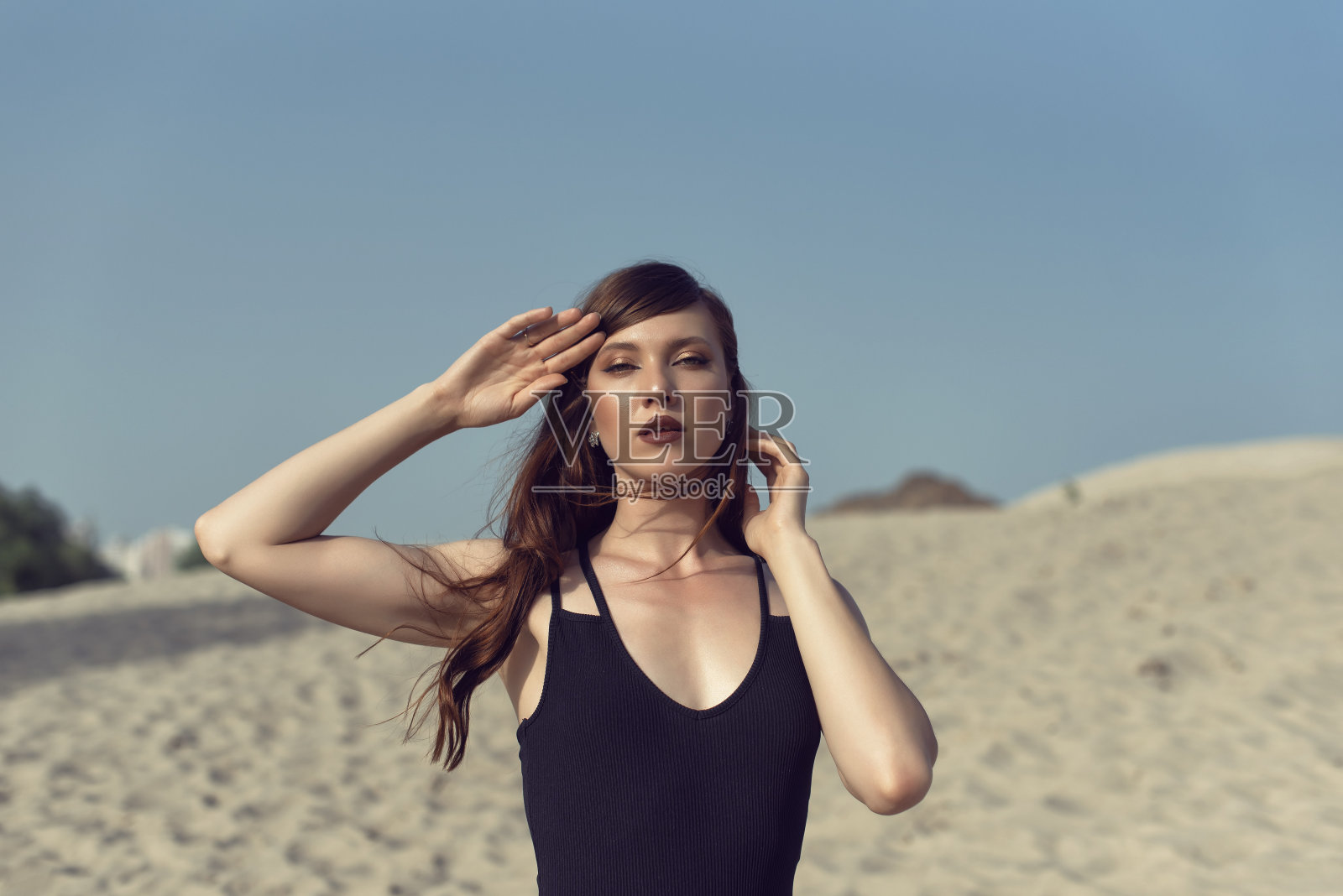 年轻的褐发女郎在炙热的沙滩上照片摄影图片
