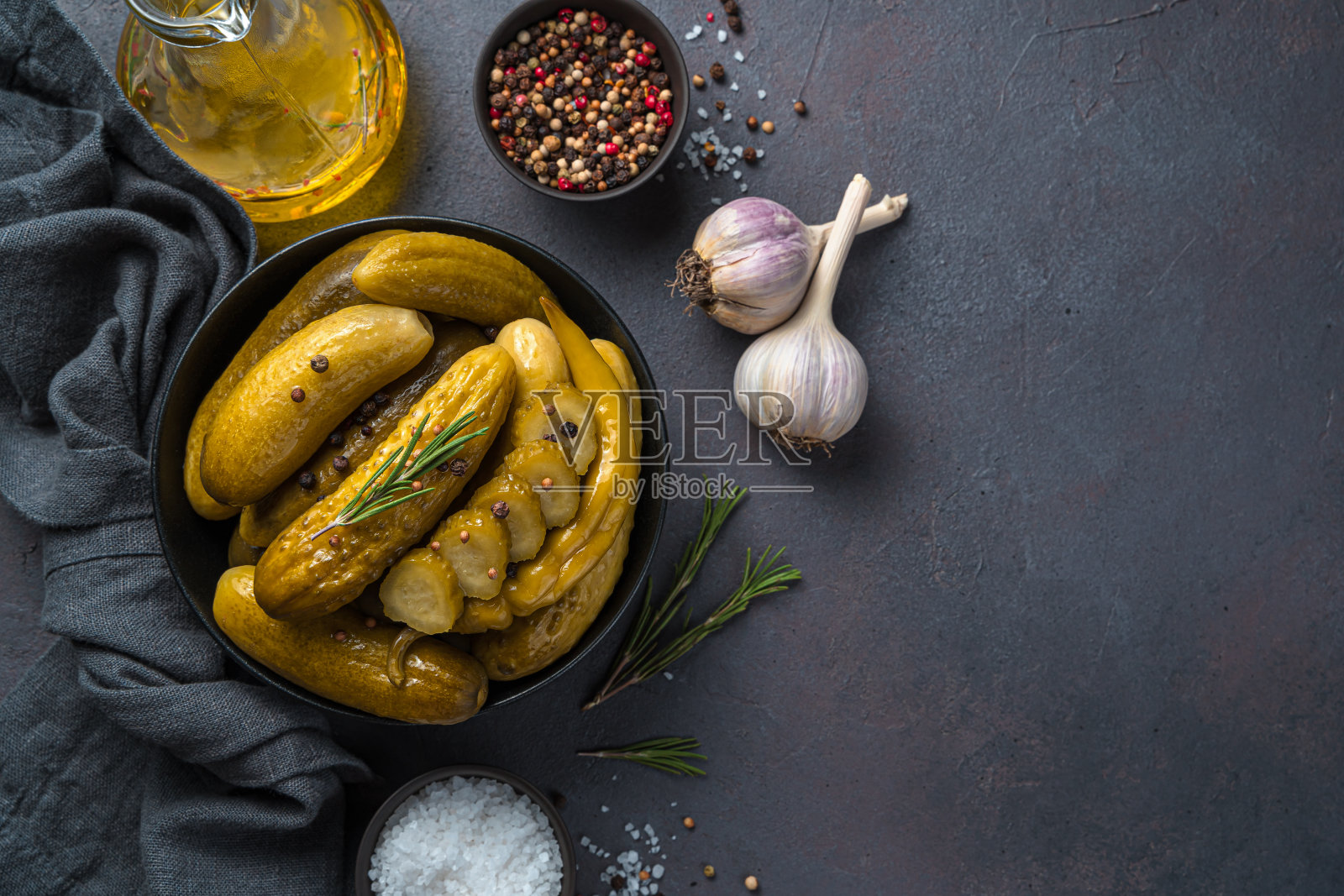 酥脆的腌黄瓜、香料和大蒜在黑色的背景上照片摄影图片
