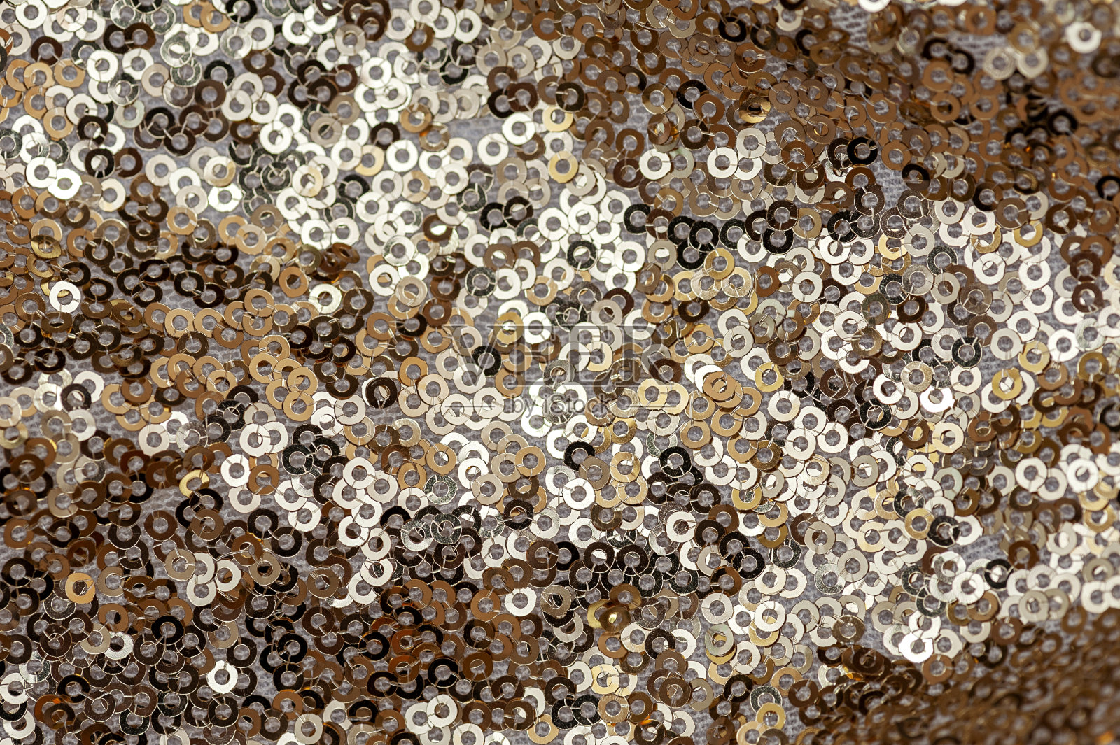 白色织物上金色圆片的纹理。从上面的观点照片摄影图片