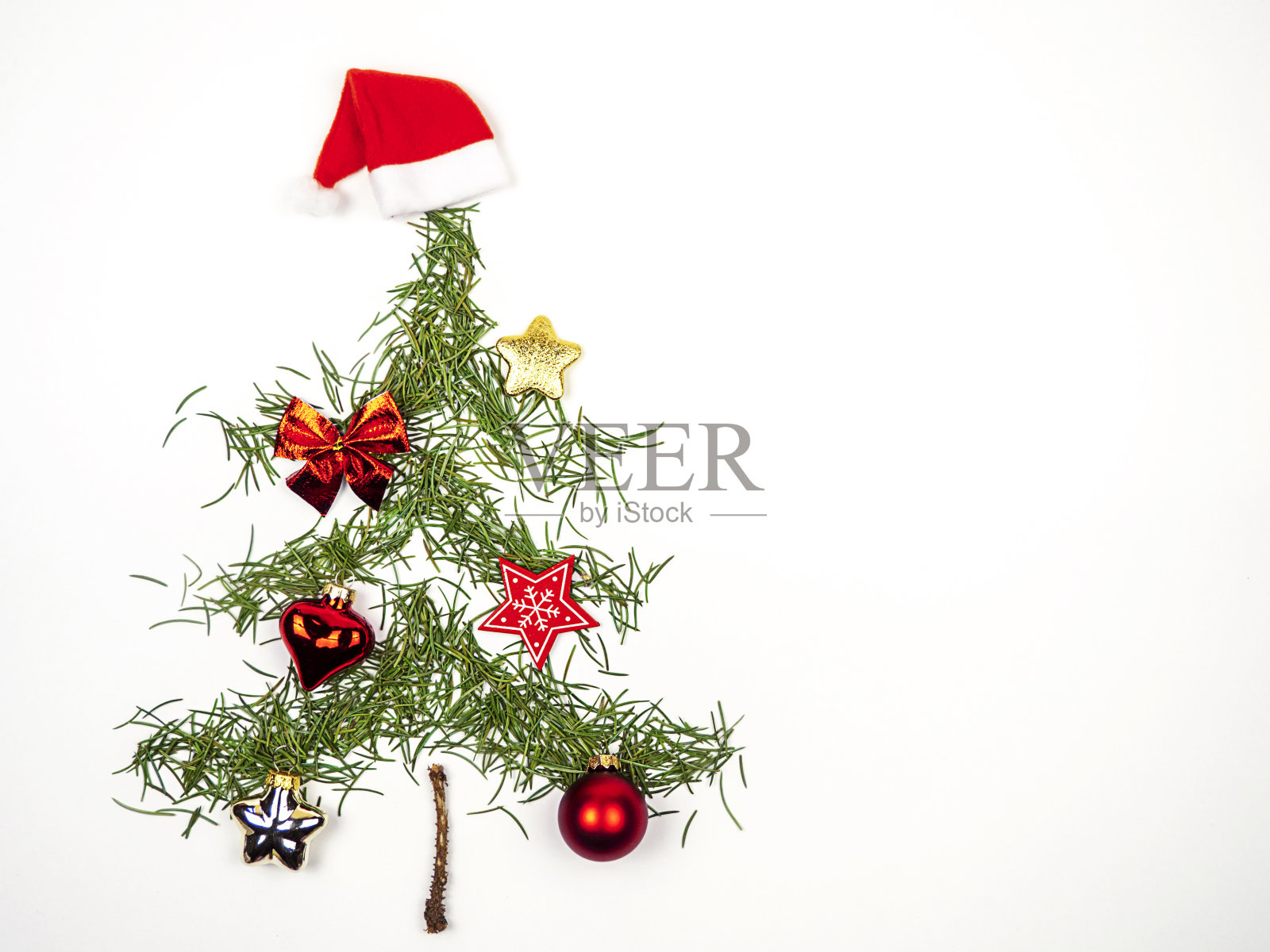 圣诞树是用云杉针叶做成的，上面有一颗红星和一颗圣诞梨，背景是浅色的。圣诞节的概念。照片摄影图片