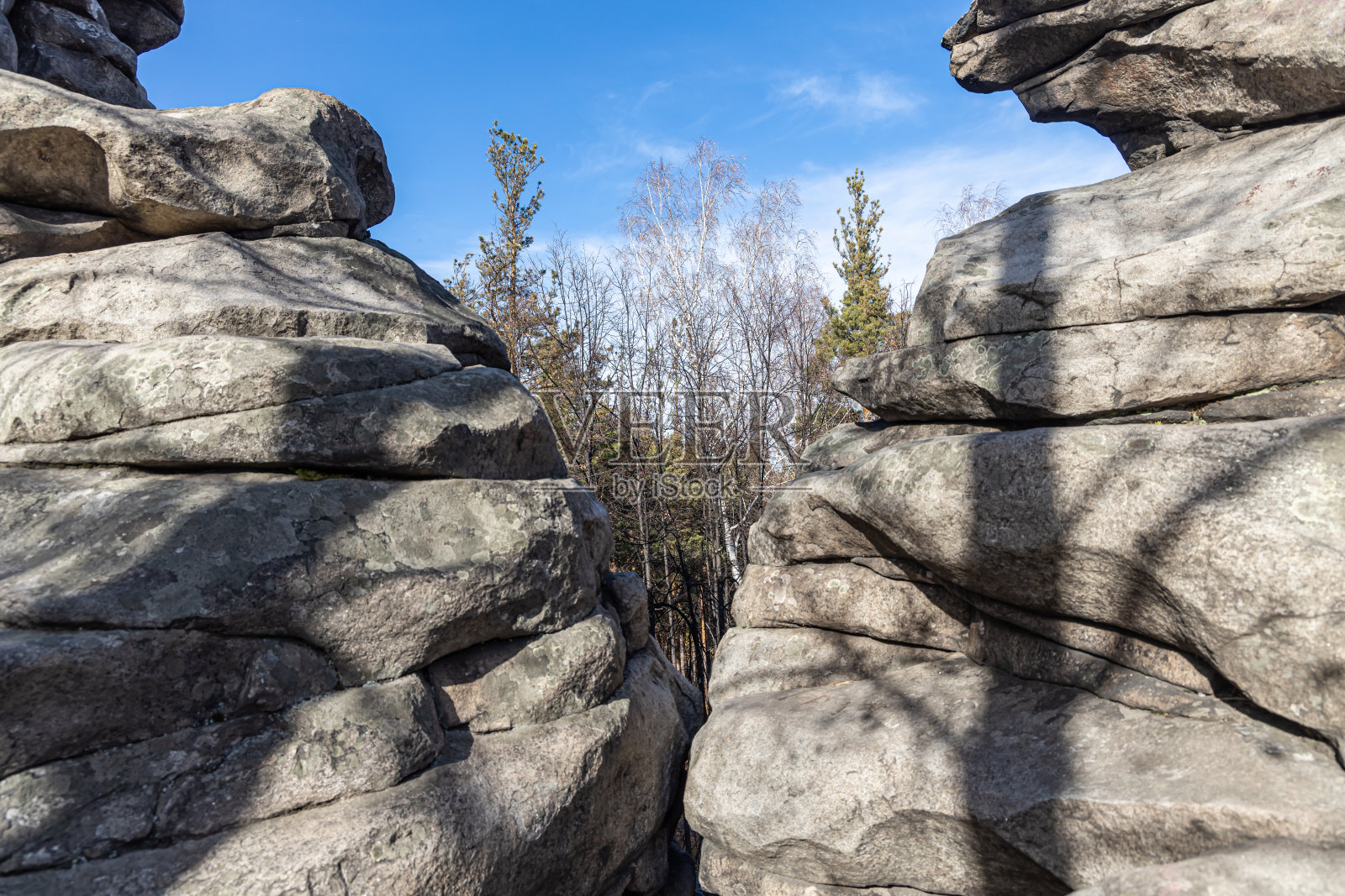 水平照片的一组灰色的山与松树和桦树在蓝色的天空背景在秋天的森林照片摄影图片