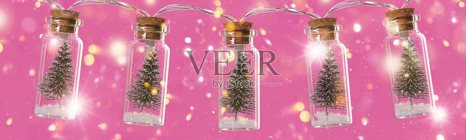 圣诞装饰。粉色抽象背景上装饰着圣诞树的花环。照片摄影图片