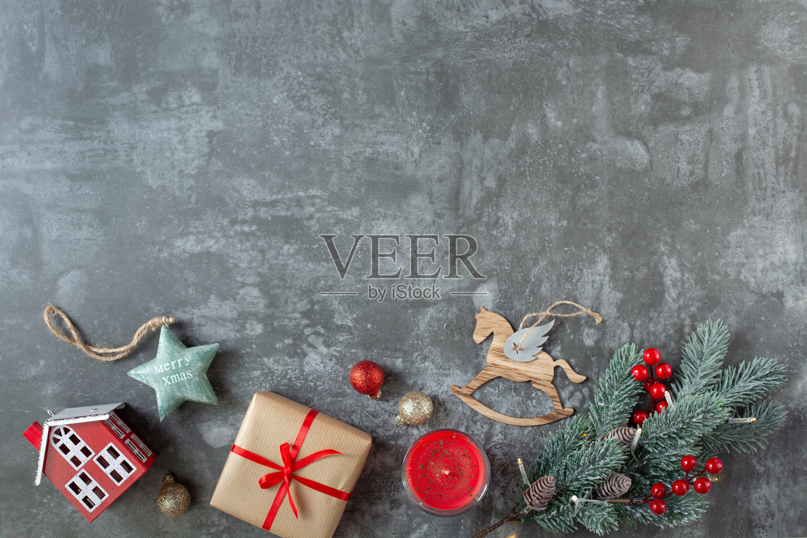 美丽的圣诞装饰和一根云杉树枝在图像底部的灰色背景上。新年主题的背景。照片摄影图片