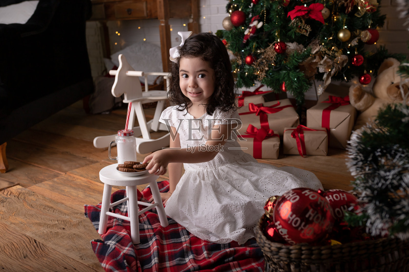 小女孩在圣诞树旁打开礼物照片摄影图片