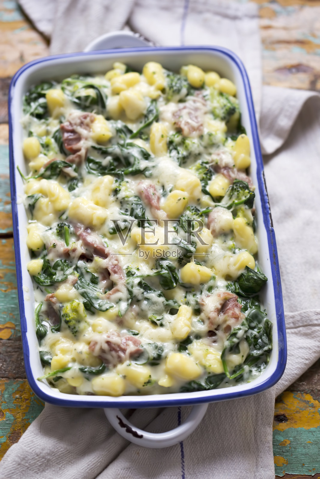 土豆汤圆配菠菜、西兰花、帕尔玛火腿和蓝奶酪酱照片摄影图片