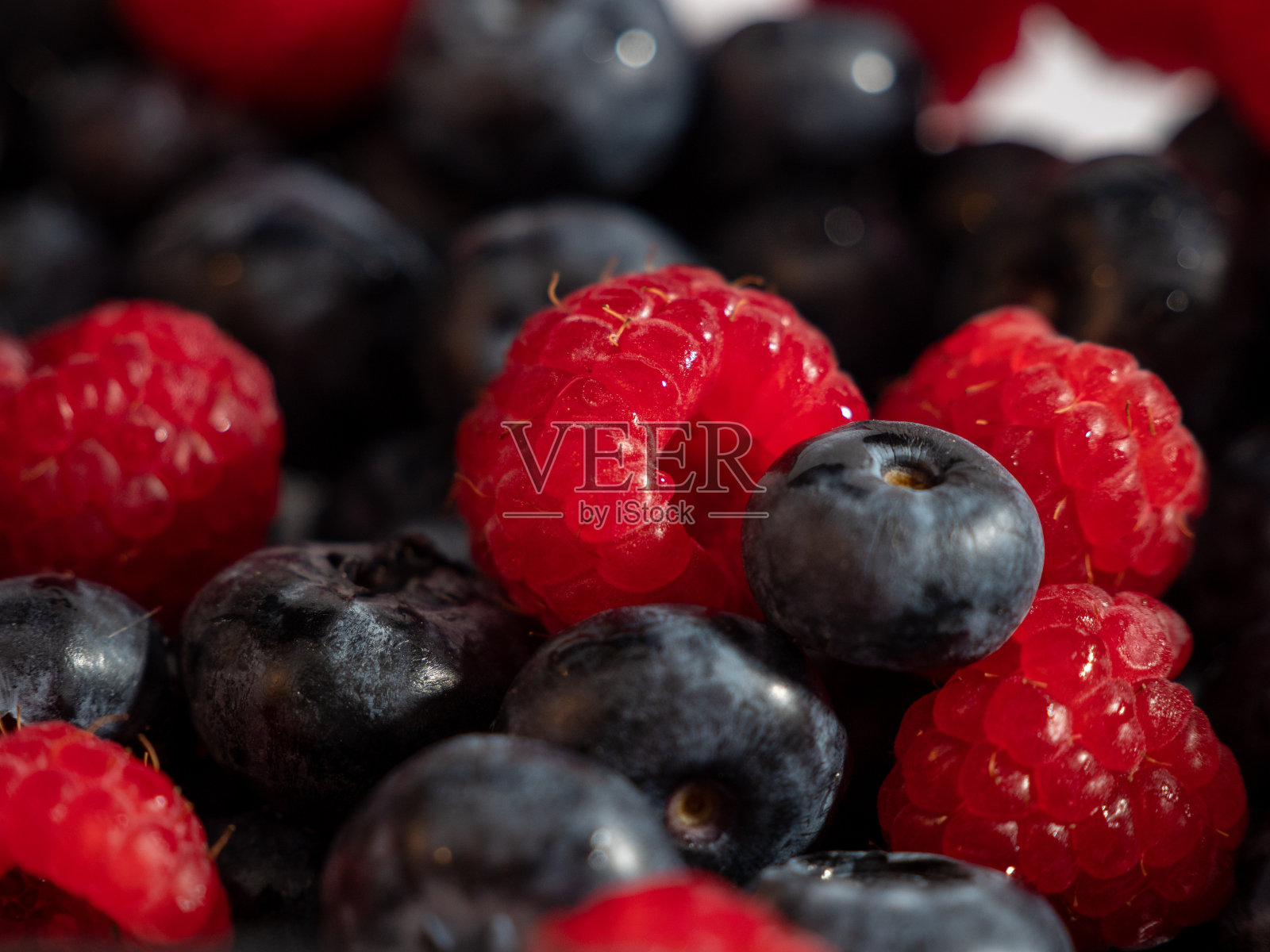 新鲜混合浆果作为背景。蓝莓和树莓照片摄影图片