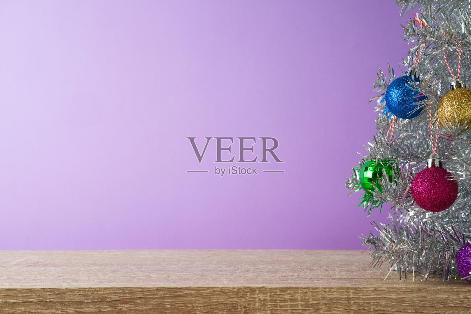 圣诞假期背景与圣诞树和装饰品在木制架子上紫色的背景。照片摄影图片