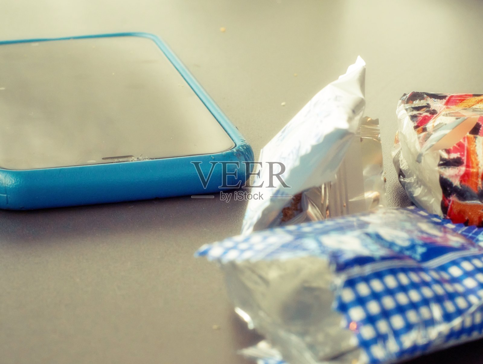 桌上放着智能手机和糖果纸照片摄影图片