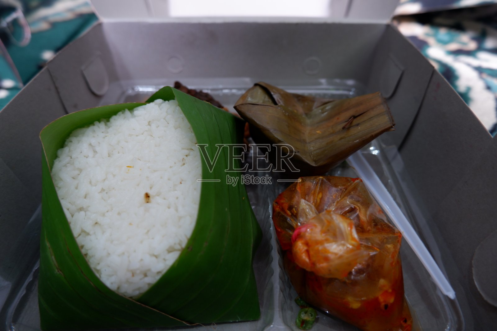 用香蕉叶包着的米饭和红辣椒酱装在盒子里照片摄影图片