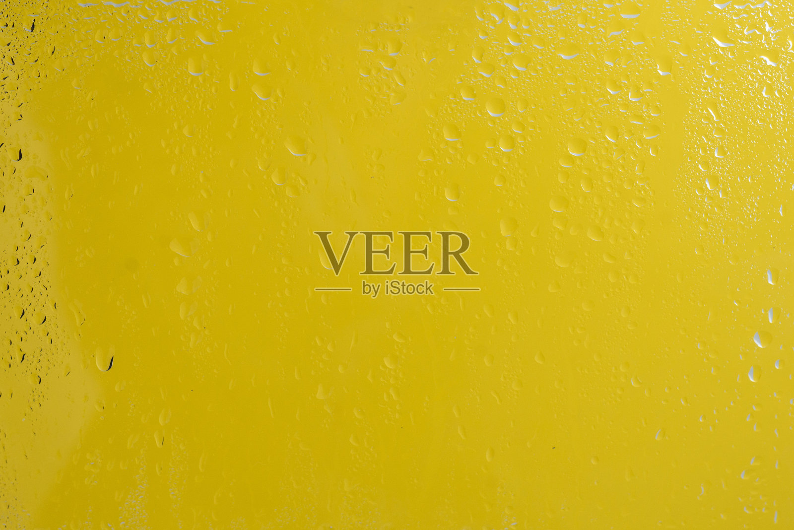 黄色背景与水滴。照片摄影图片