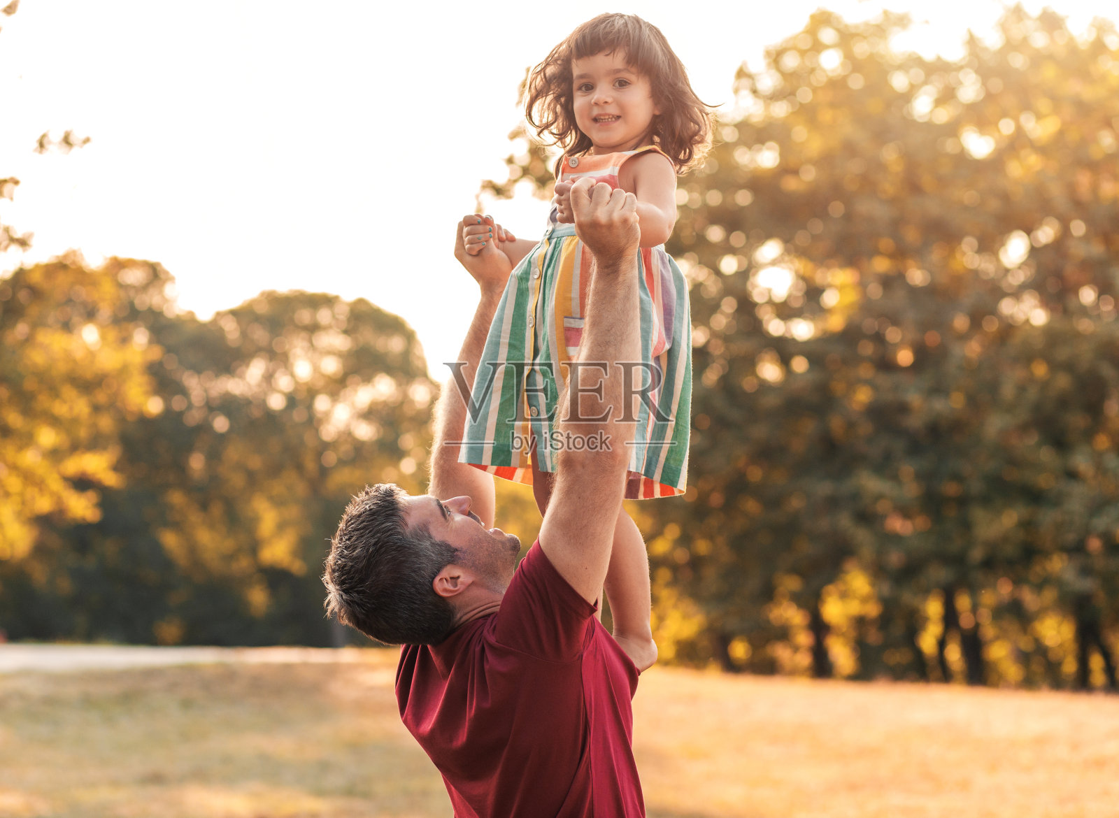 快乐的父亲和他的女儿在公园玩。照片摄影图片