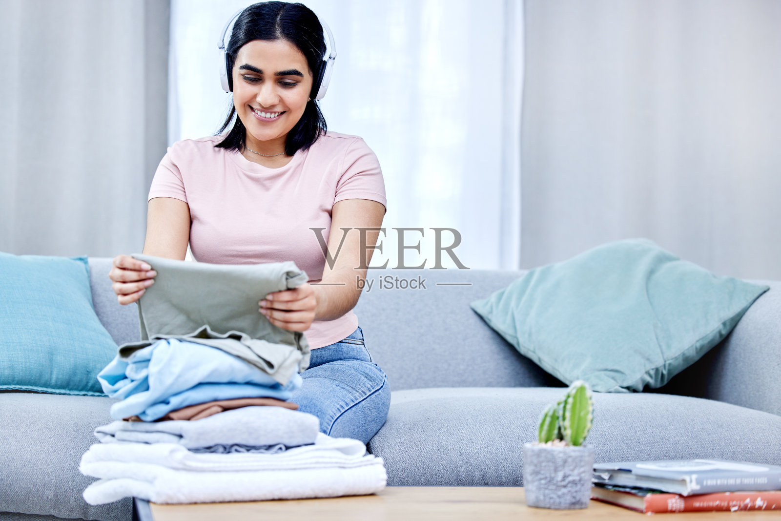 一名年轻女子在家里叠衣服的照片照片摄影图片