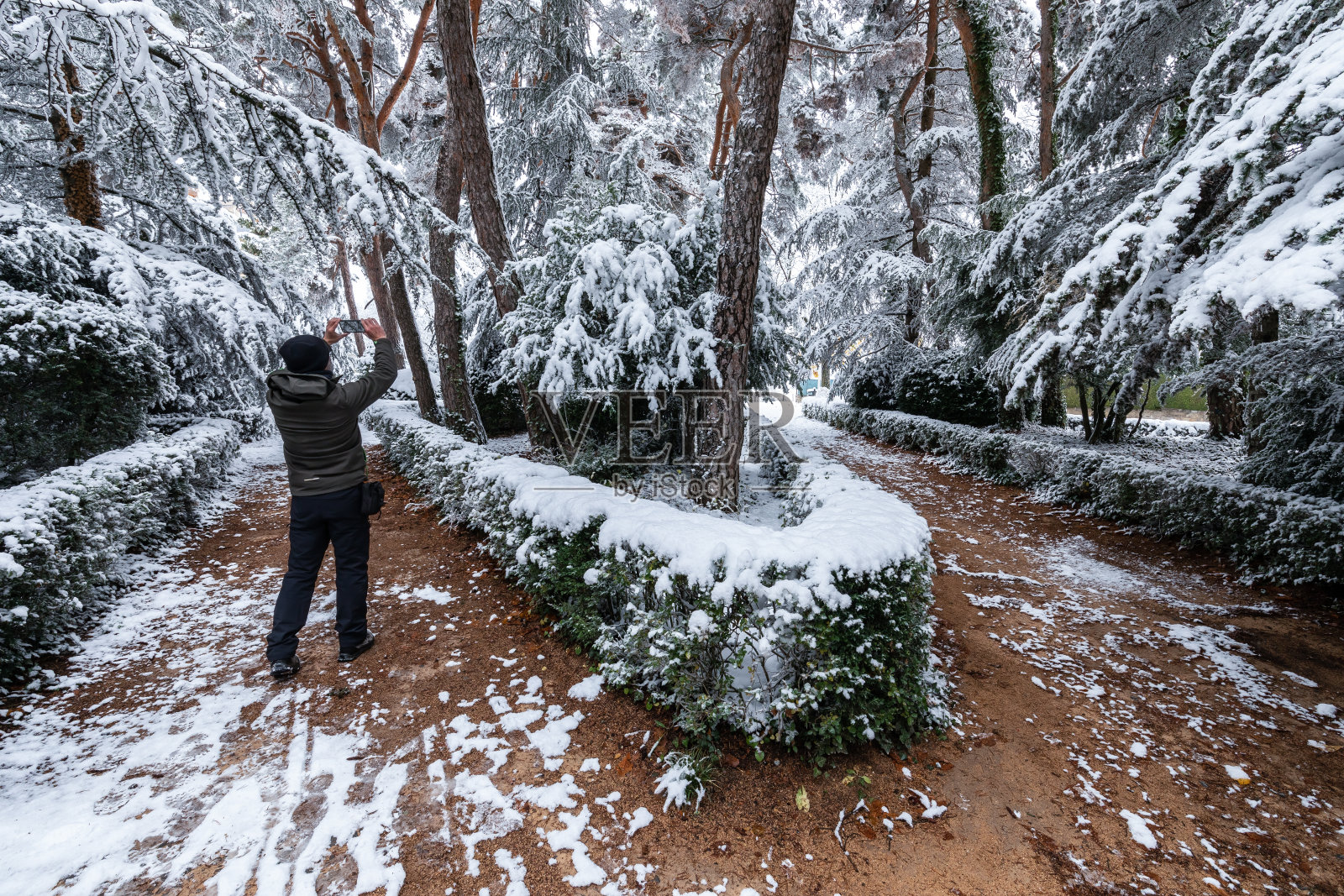 在秋天拍摄雪景城市公园的徒步旅行者照片摄影图片