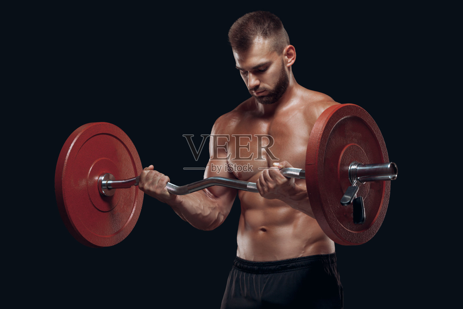 一个强壮的男人健美者与一个杠铃隔离在黑色背景锻炼的正面视图照片摄影图片