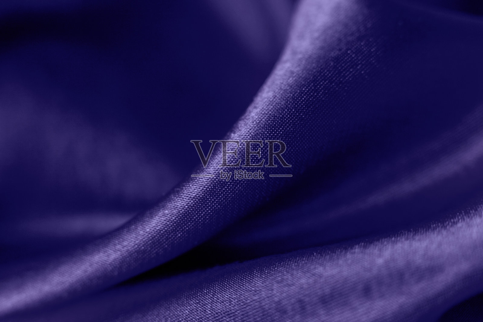 时髦的颜色非常接近光滑的丝绸背景。关闭了。优雅明亮的缎子波浪。织物背景，从上面看。奢华的紫布质感。照片摄影图片