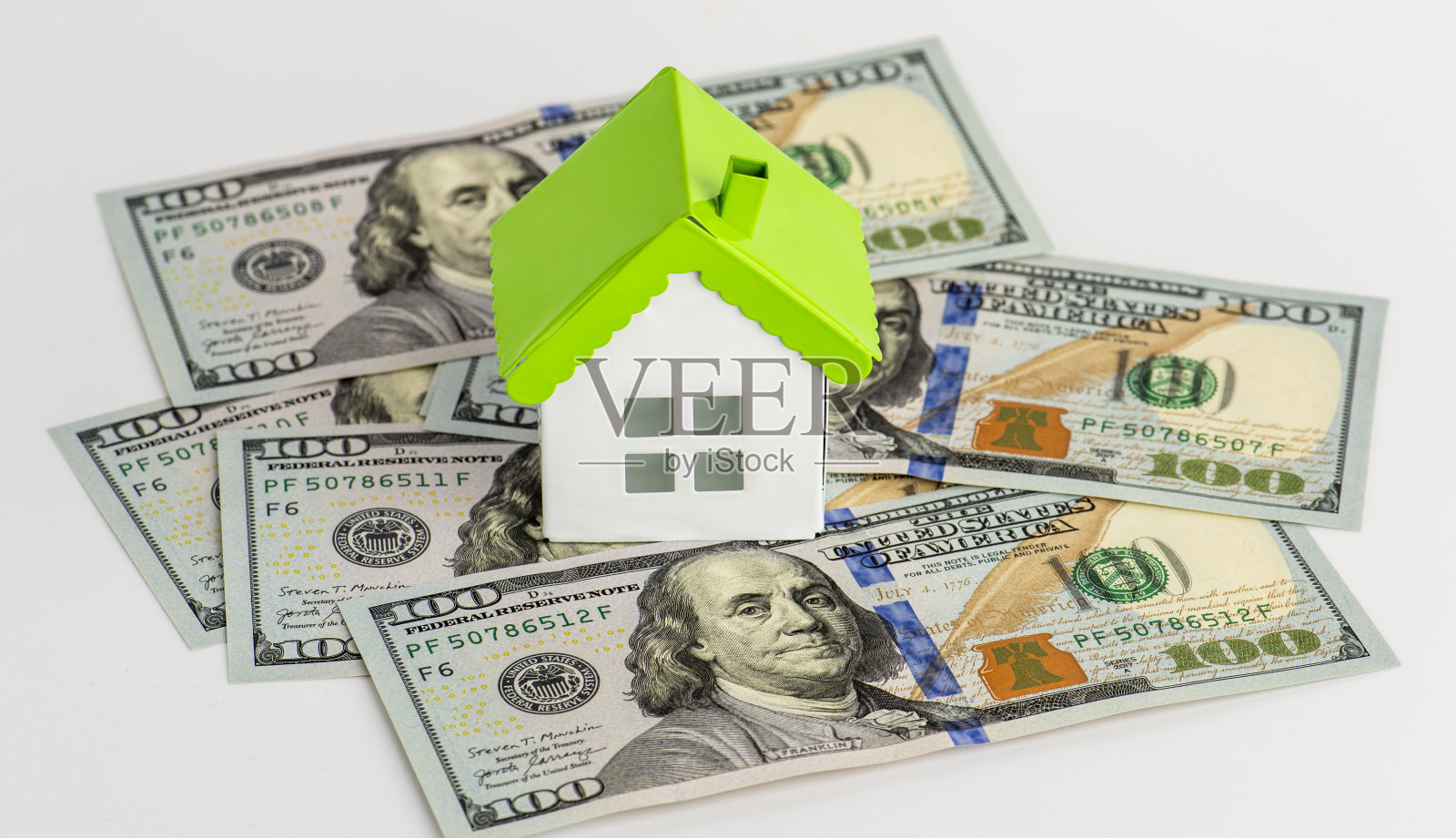 100美元的钞票和迷你房子模型。照片摄影图片