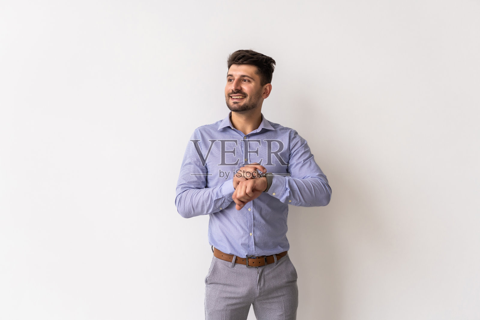 年轻人看着白色背景的手表照片摄影图片