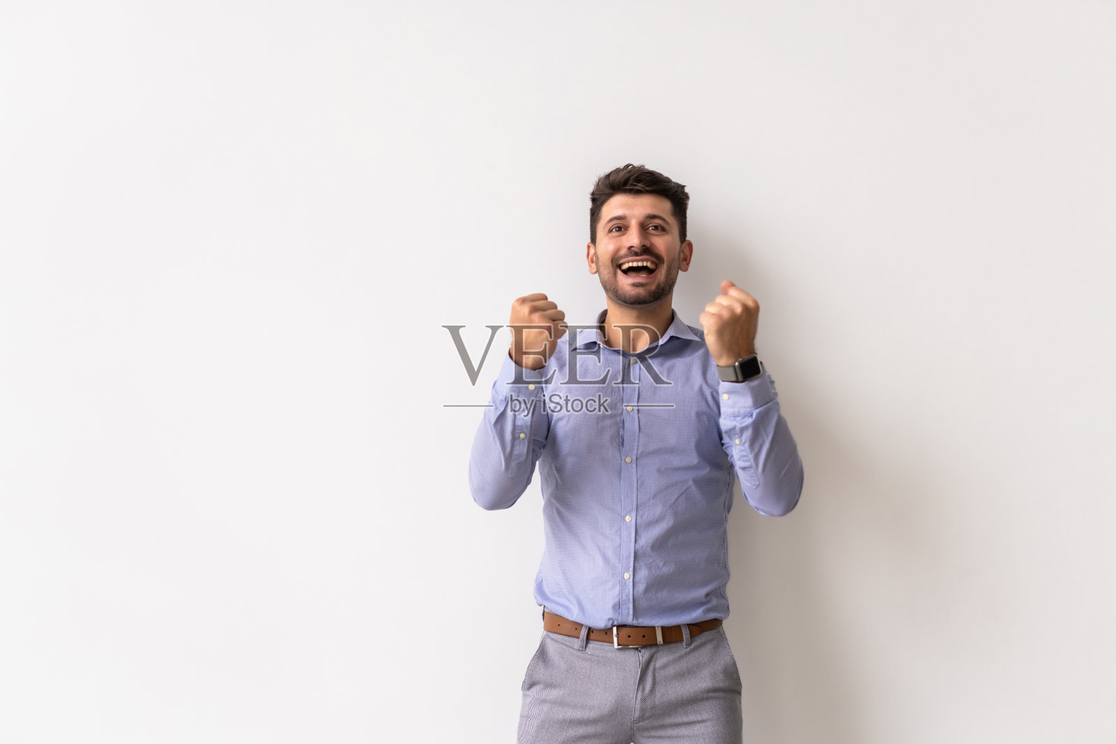 一个满意的年轻人庆祝成功的白色背景的肖像照片摄影图片